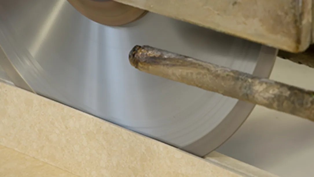 Close-up of a diamond saw cutting a quartz slab during fabrication.