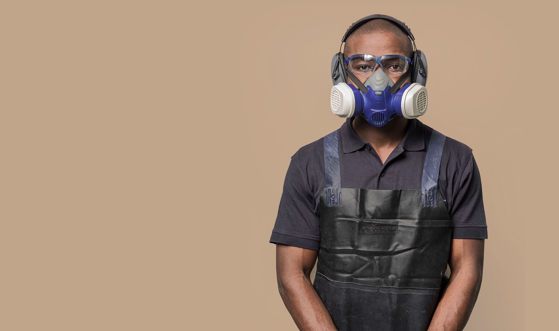 Fabricator wearing safety gear — respirator mask, goggles, ear protection, and apron — representing Caesarstone’s Good Practice Guide for safe fabrication.